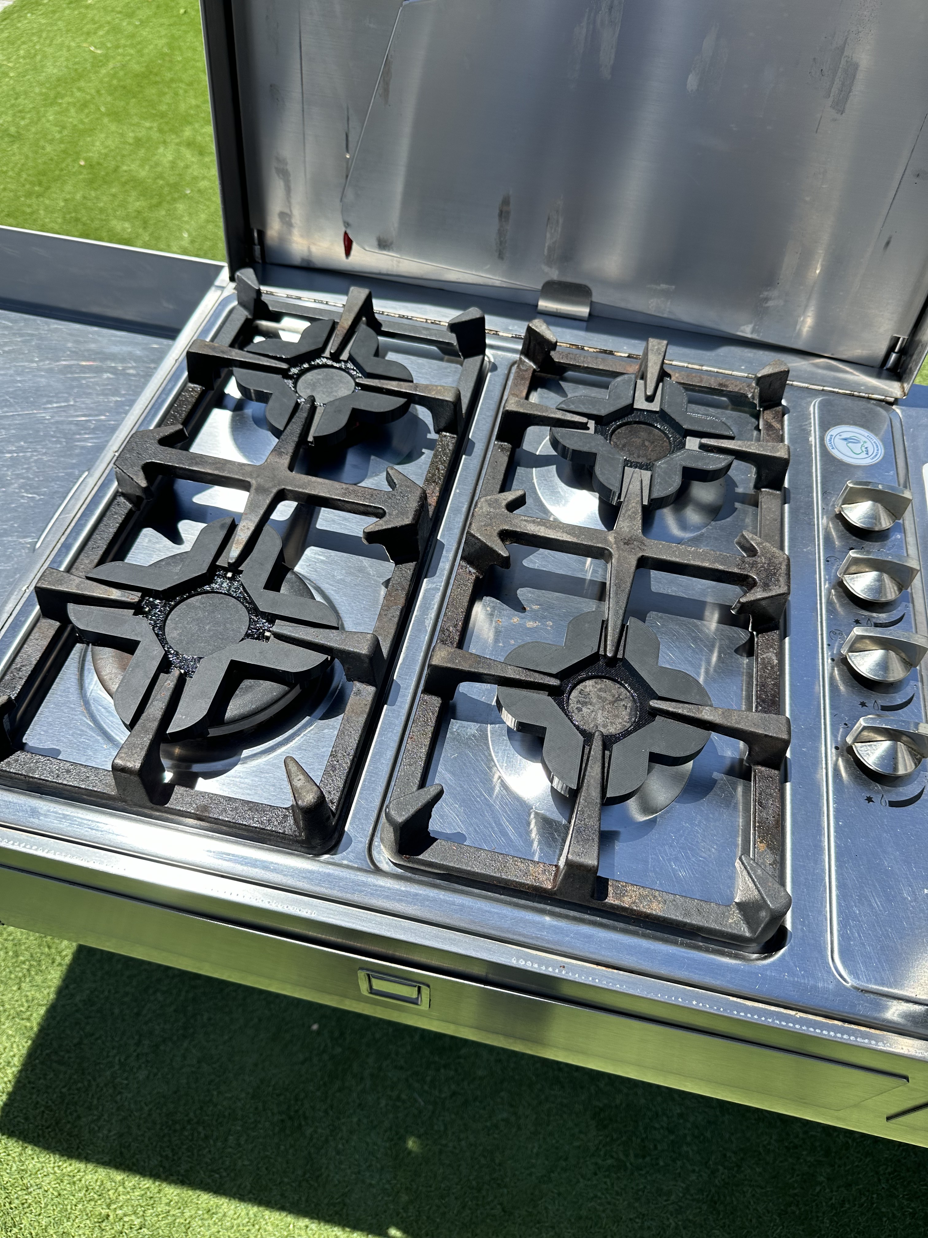 3D-printed burner stove protectors fitted to a caravan cooktop